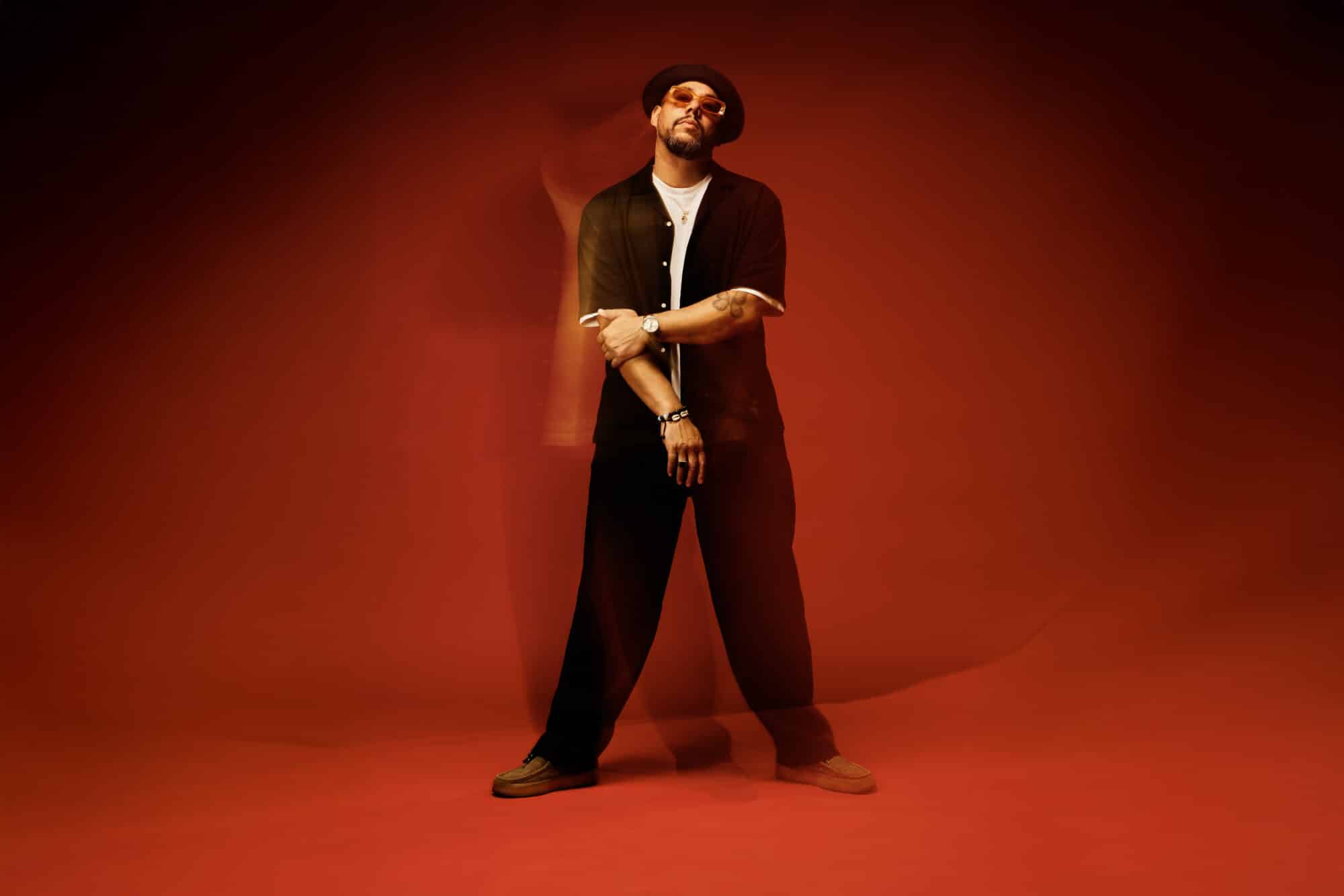 Ben l’Oncle Soul posant devant un fond rouge illuminé d’effets de lumière.