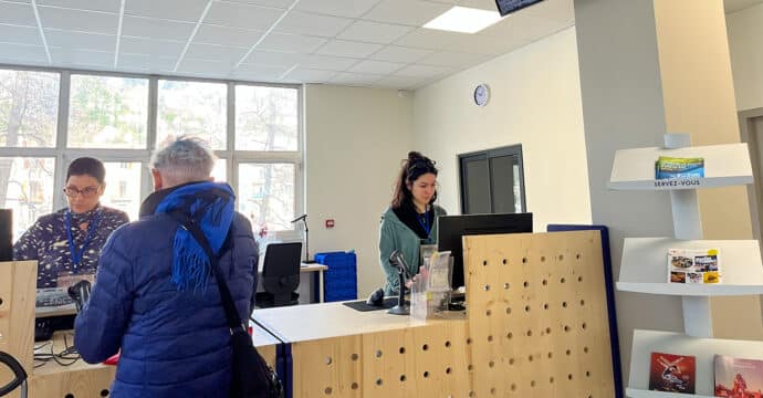 Usager et médiathécaires à l'espace prêts et retours.